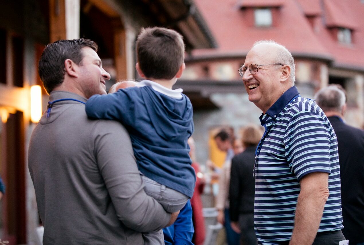 Father and son talking to older gentleman.